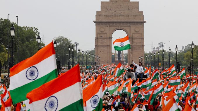 People wave Indian flags in support of the Indian Armed Forces, following the ceasefire announcement between India and Pakistan, in Delhi