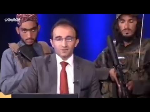 عناصر طالبان يحملون السلاح خلف مذيع على الهواء